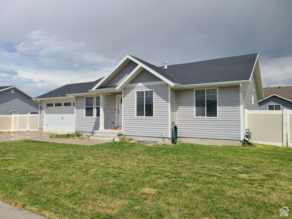 Ranch-style house featuring a garage, driveway, and board and batten siding