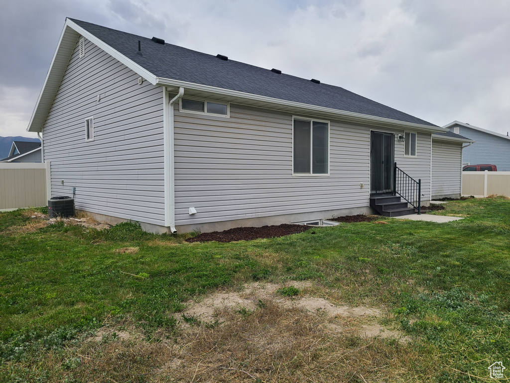 Back of house featuring entry steps and roof with shingles