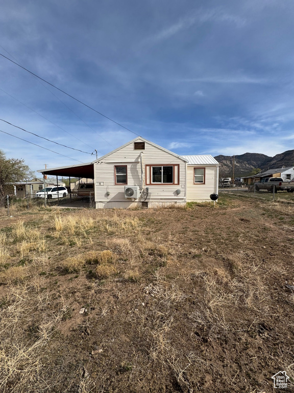View of front of house with fence, ac unit, an attached carport, and a mountain view