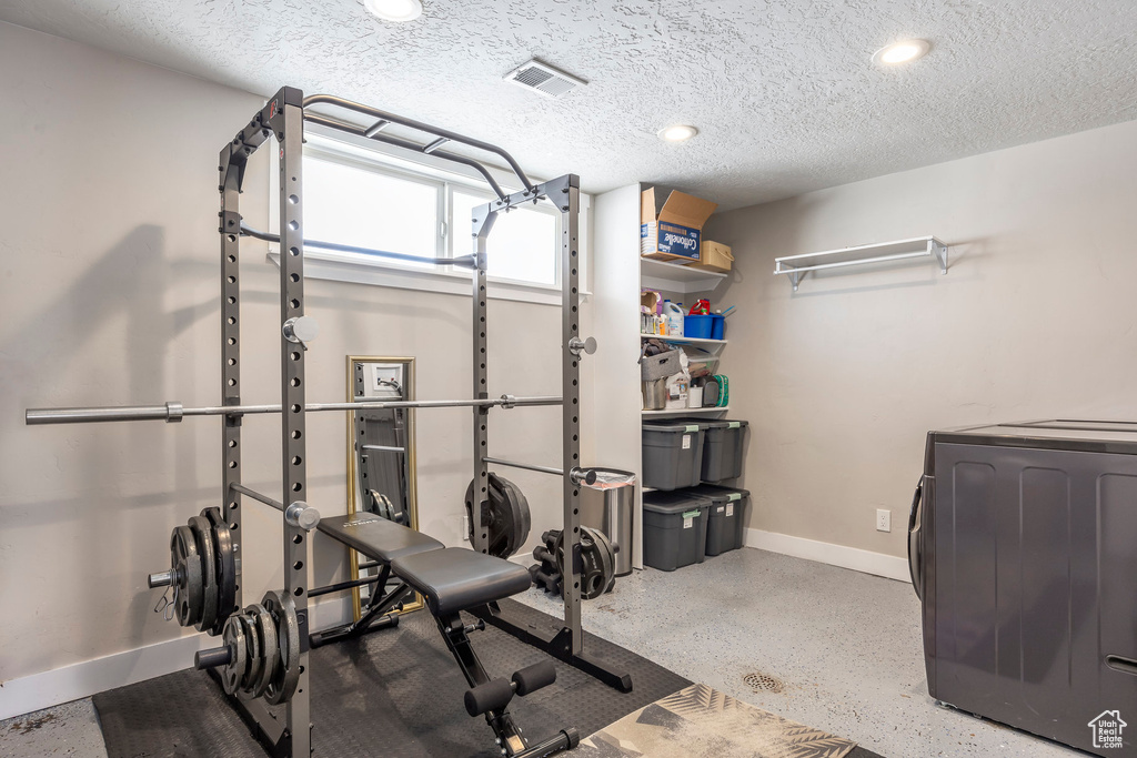 Workout room featuring baseboards, washer / dryer, recessed lighting, and a textured ceiling