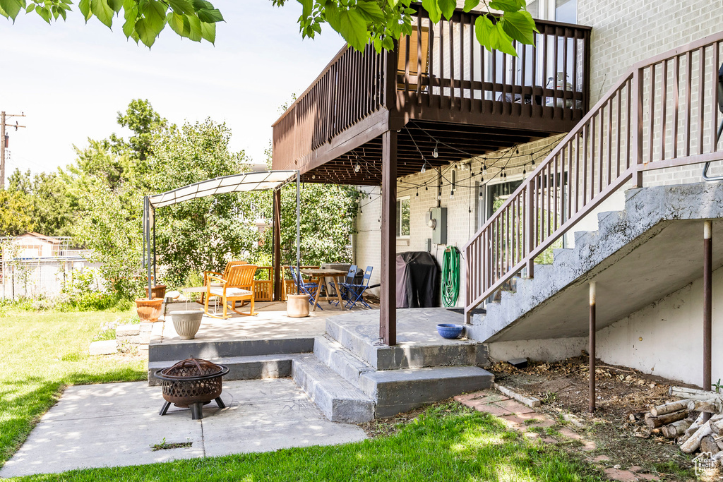 View of patio featuring stairs, an outdoor fire pit, and a wooden deck