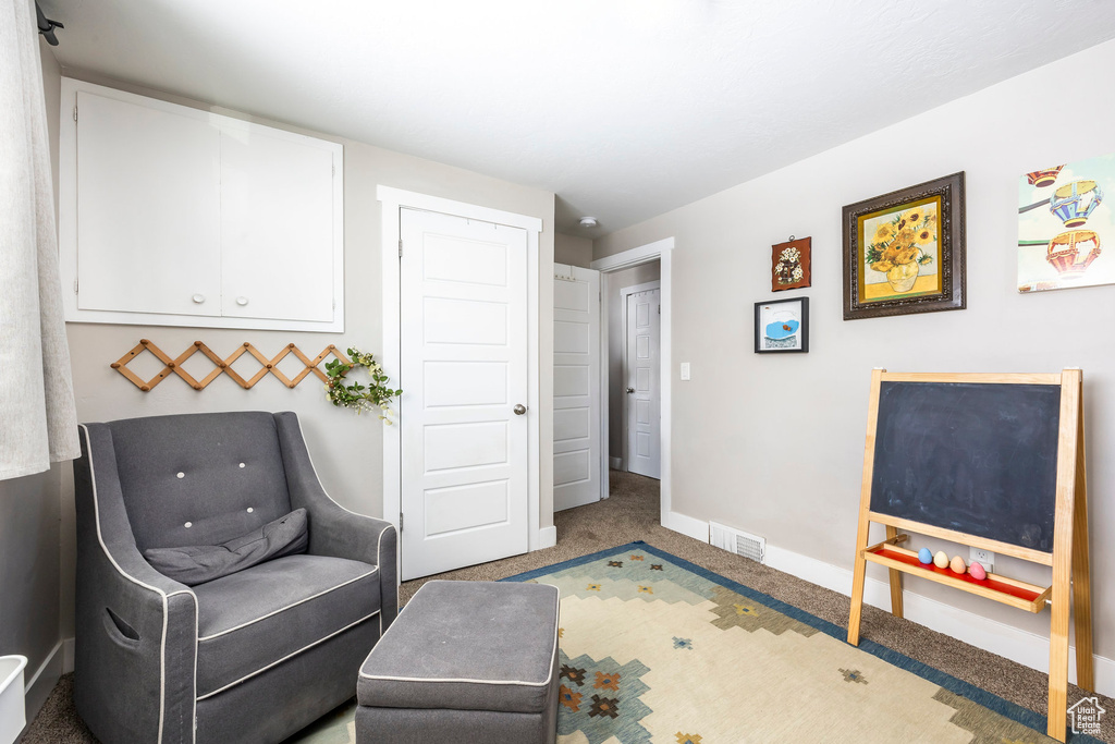 Sitting room featuring carpet flooring and baseboards