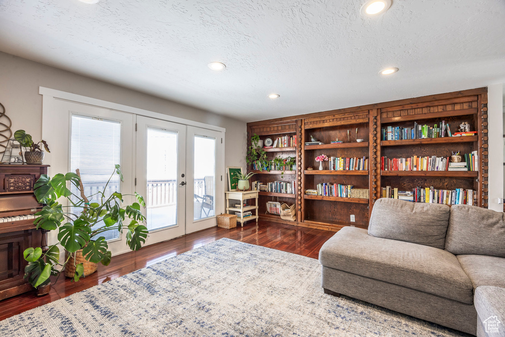 Living area with wood finished floors, french doors, recessed lighting, and a textured ceiling