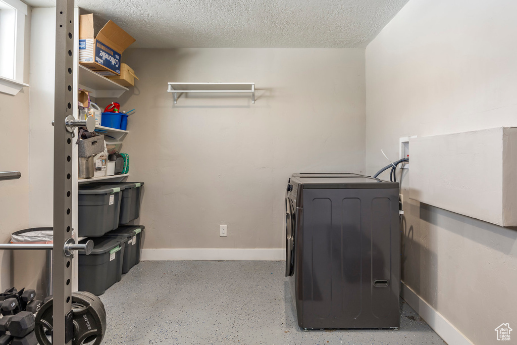 Laundry room featuring washer hookup, baseboards, and a textured ceiling