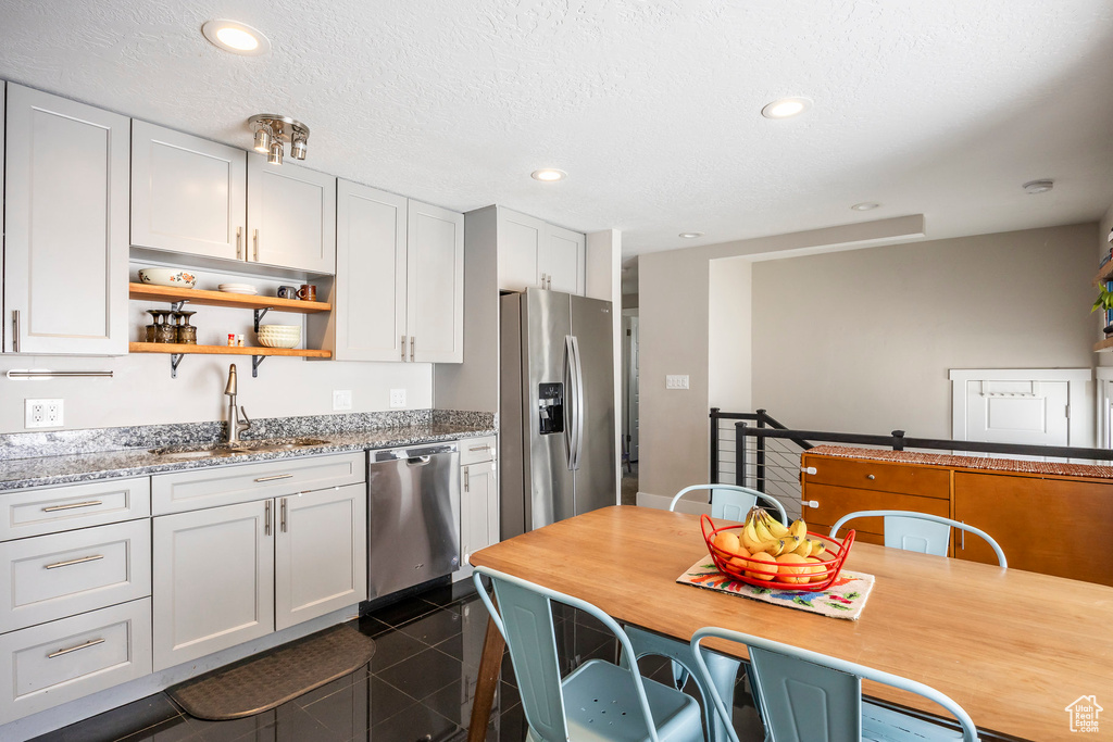 Kitchen featuring stainless steel appliances, granite tiled floors, a sink, open shelves, and recessed lighting