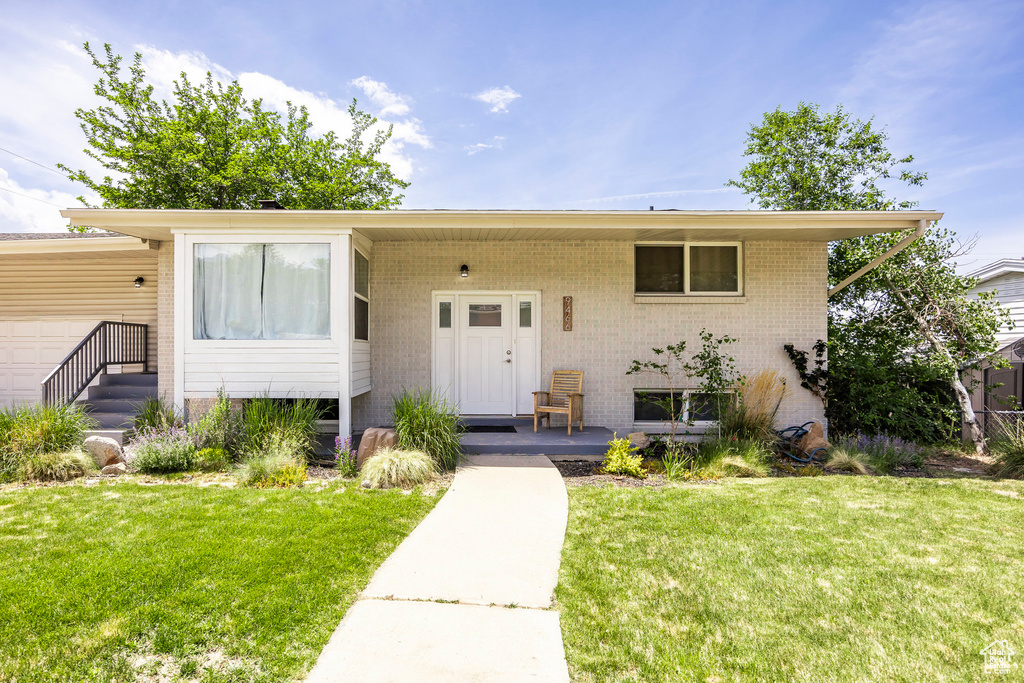 View of front of property with a front yard and covered porch
