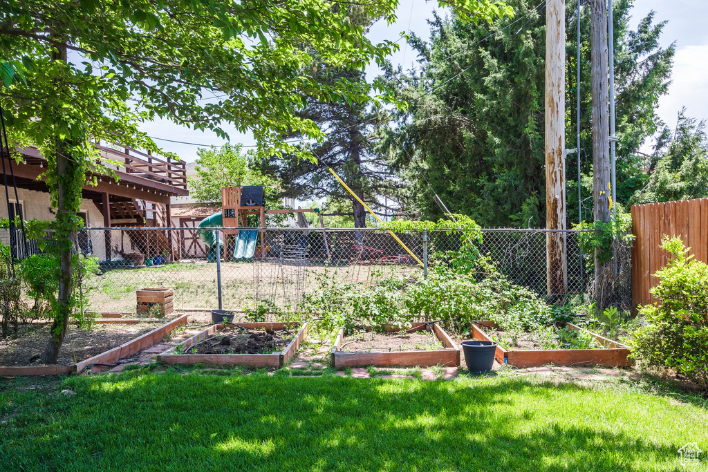 View of yard with a garden and a playground
