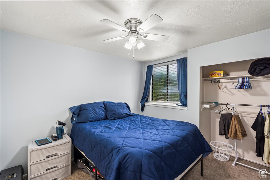 Bedroom featuring carpet flooring, a textured ceiling, and ceiling fan