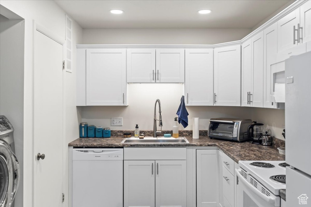 Kitchen featuring a sink, white appliances, washer / dryer, a toaster, and white cabinets
