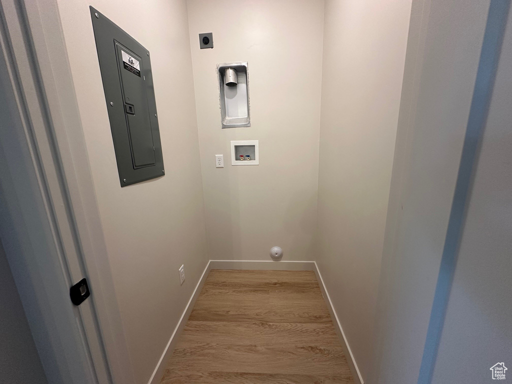 Laundry room featuring washer hookup, electric panel, light wood-type flooring, and hookup for an electric dryer