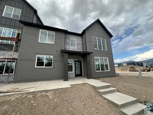 Rear view of property with board and batten siding and a patio