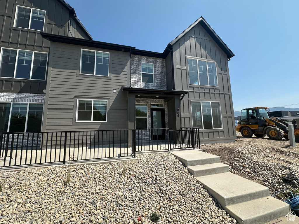 View of front of house featuring board and batten siding and a patio area