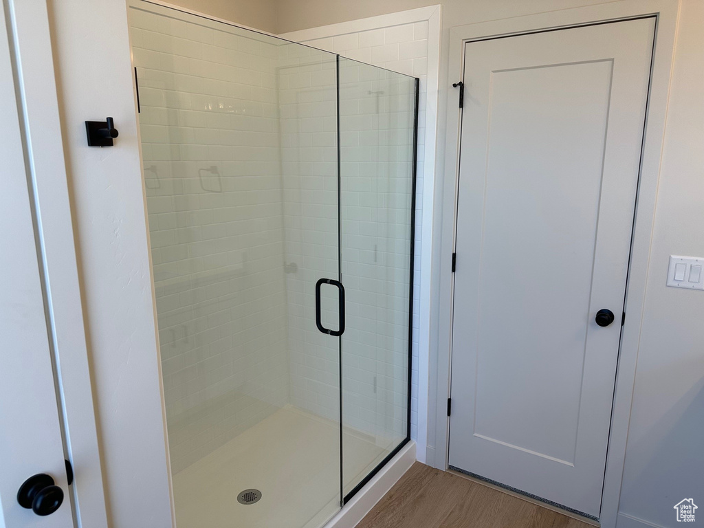 Full bath featuring a stall shower and wood finished floors