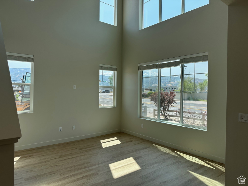 Spare room with a high ceiling and wood finished floors