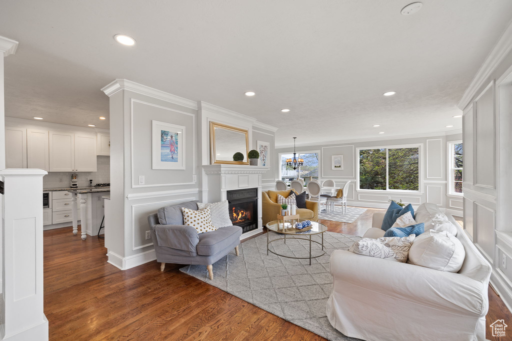 Living area featuring a decorative wall, a warm lit fireplace, and recessed lighting