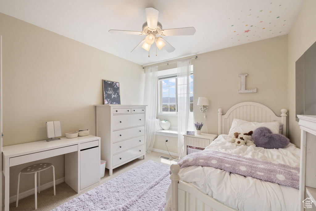 Bedroom featuring light colored carpet, ceiling fan, and baseboards