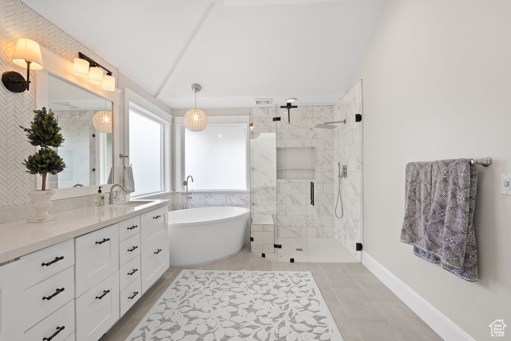 Full bathroom with a shower stall, a freestanding bath, vanity, and tile patterned flooring