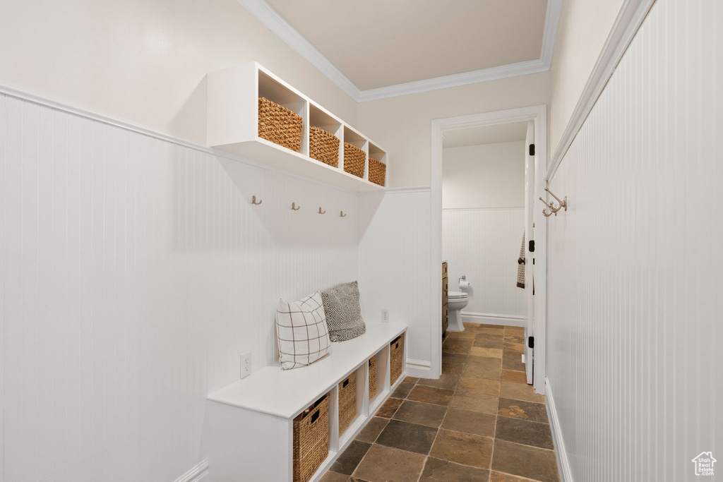 Mudroom with stone tile flooring and crown molding