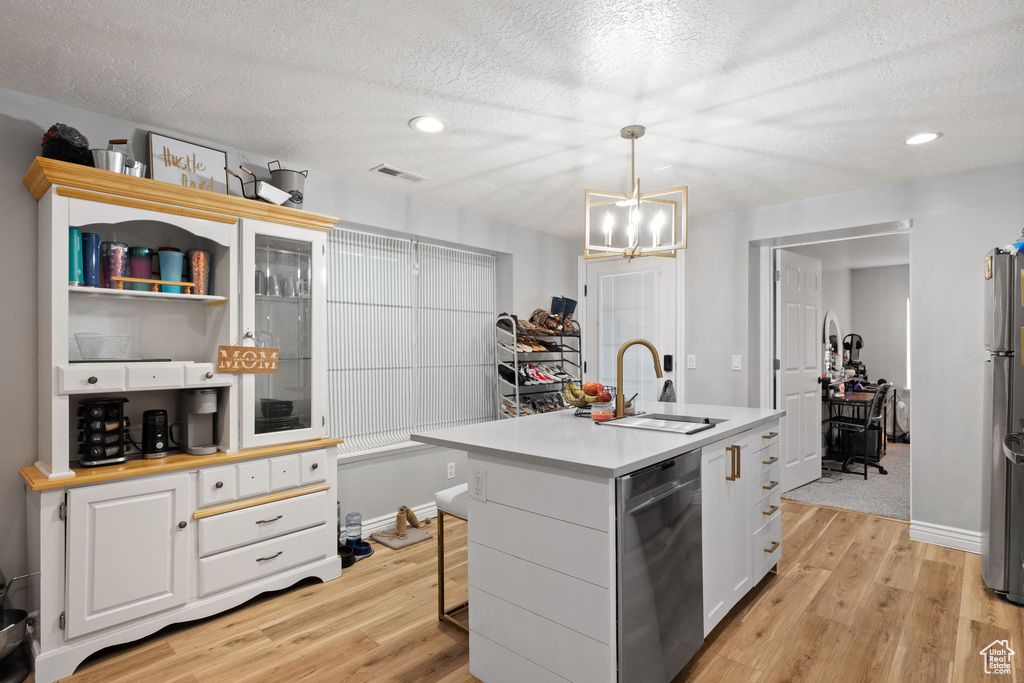 Kitchen with light countertops, visible vents, a sink, light wood-style flooring, and appliances with stainless steel finishes