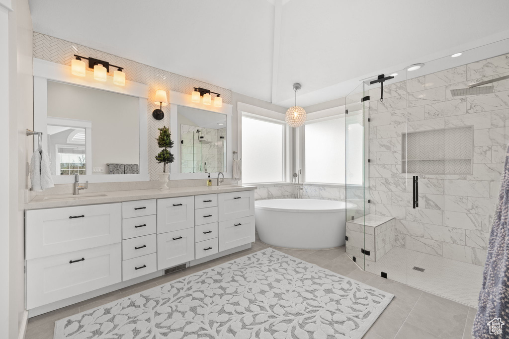 Full bathroom with a freestanding tub, a sink, a shower stall, and double vanity