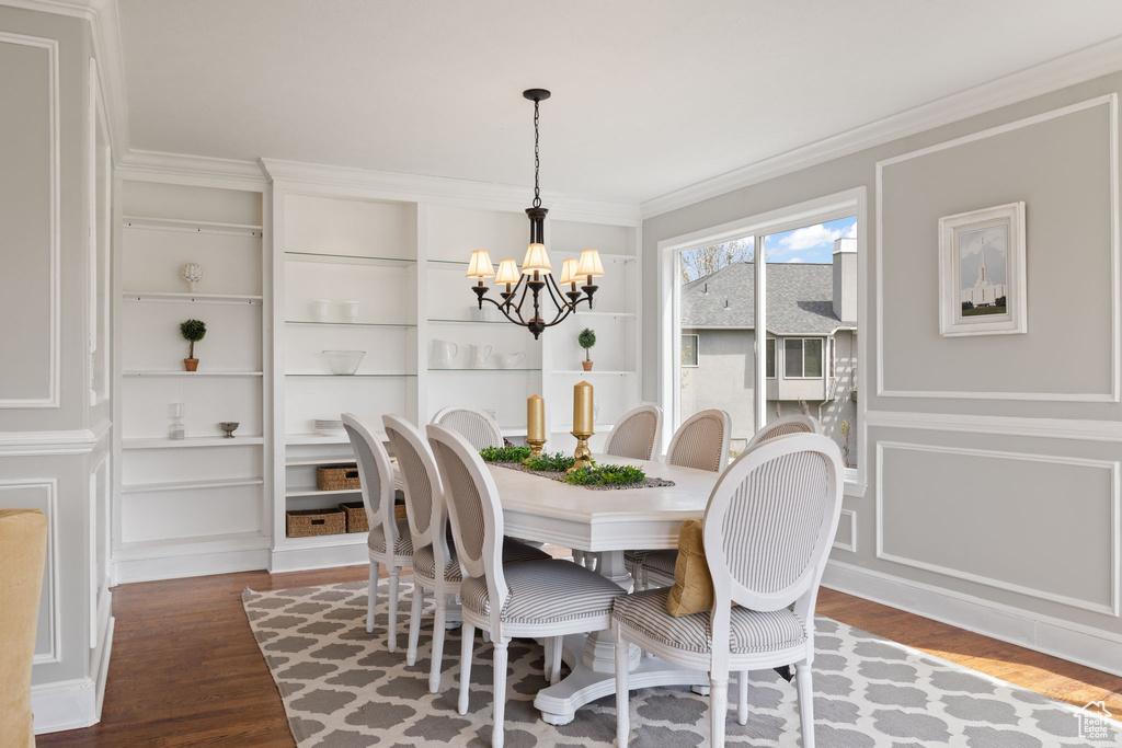 Dining area featuring a notable chandelier, built in features, and wood finished floors