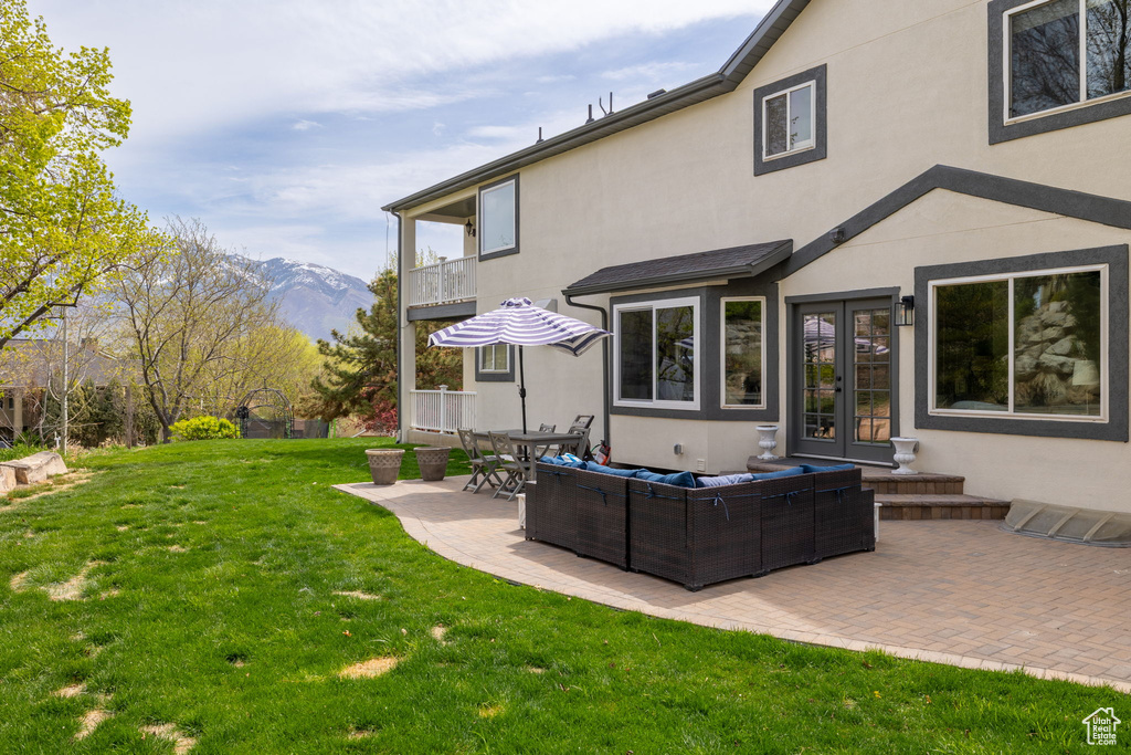 Back of house featuring stucco siding, french doors, a patio area, and a balcony