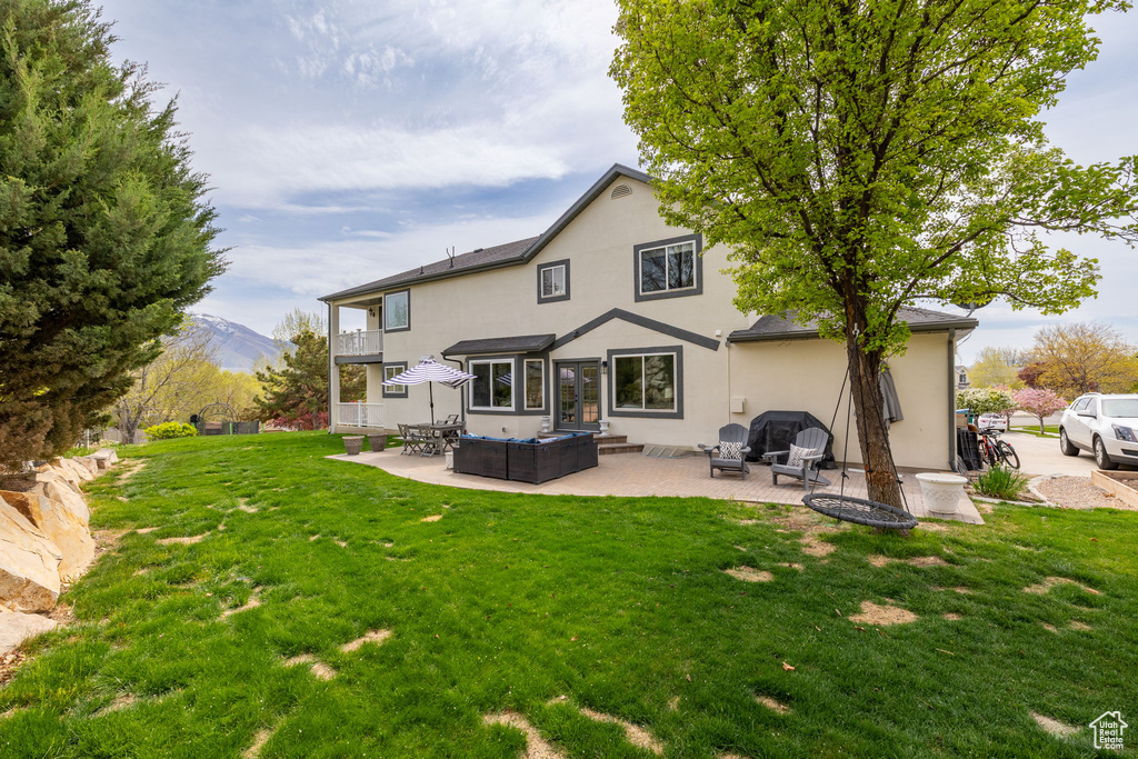 Back of property with a yard, outdoor lounge area, a patio area, and stucco siding