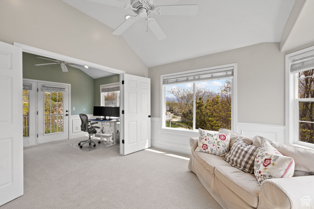Carpeted home office with wainscoting, a ceiling fan, a wealth of natural light, and lofted ceiling