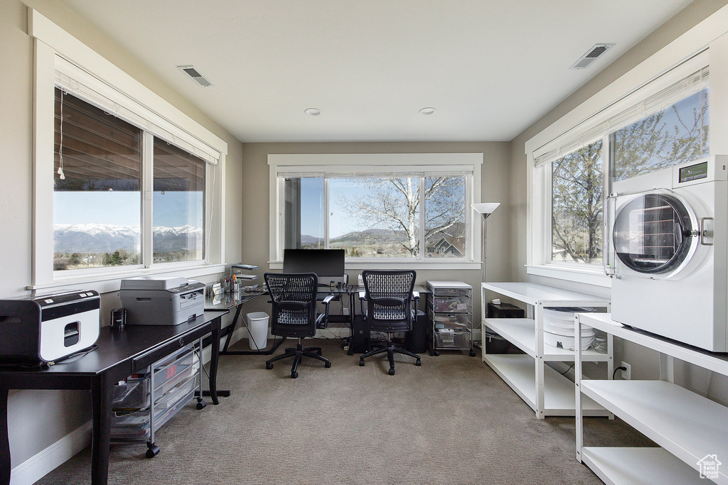 Carpeted office with stacked washer / dryer