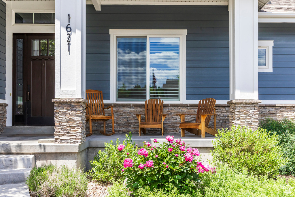 View of exterior entry featuring a porch and stone siding