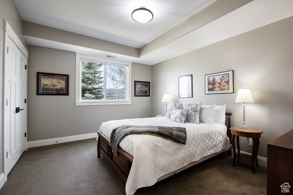 Bedroom with dark carpet and baseboards