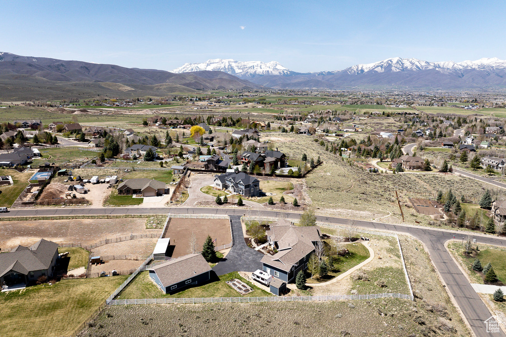 Aerial view of property and surrounding area with a mountain backdrop and nearby suburban area