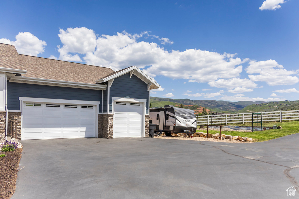 Garage with concrete driveway and a mountain view
