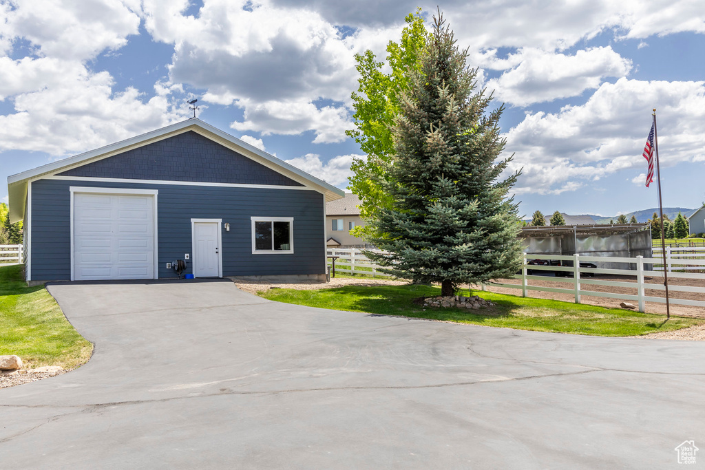 View of front facade with asphalt driveway and a garage