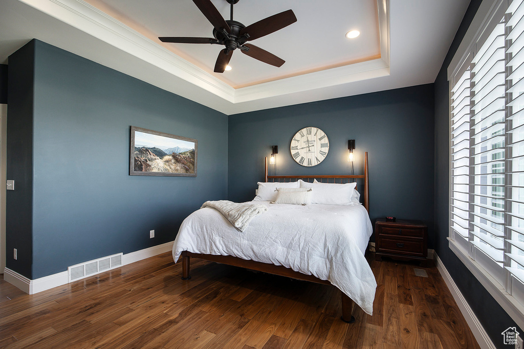 Bedroom featuring a tray ceiling, wood finished floors, baseboards, a ceiling fan, and recessed lighting