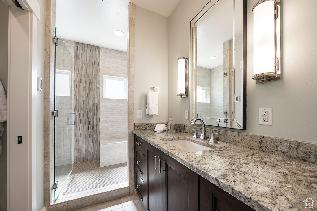 Full bath featuring vanity, a shower stall, and tile patterned flooring