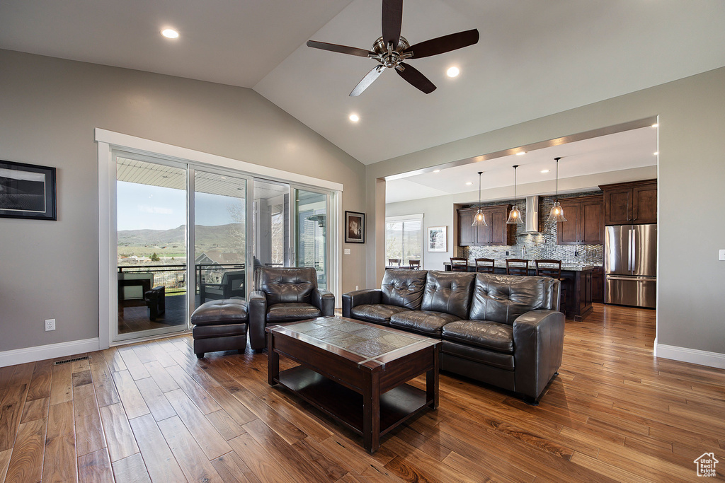 Living room featuring dark wood-style floors, vaulted ceiling, ceiling fan, baseboards, and recessed lighting