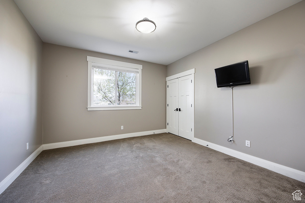 Unfurnished bedroom featuring carpet, baseboards, and a closet