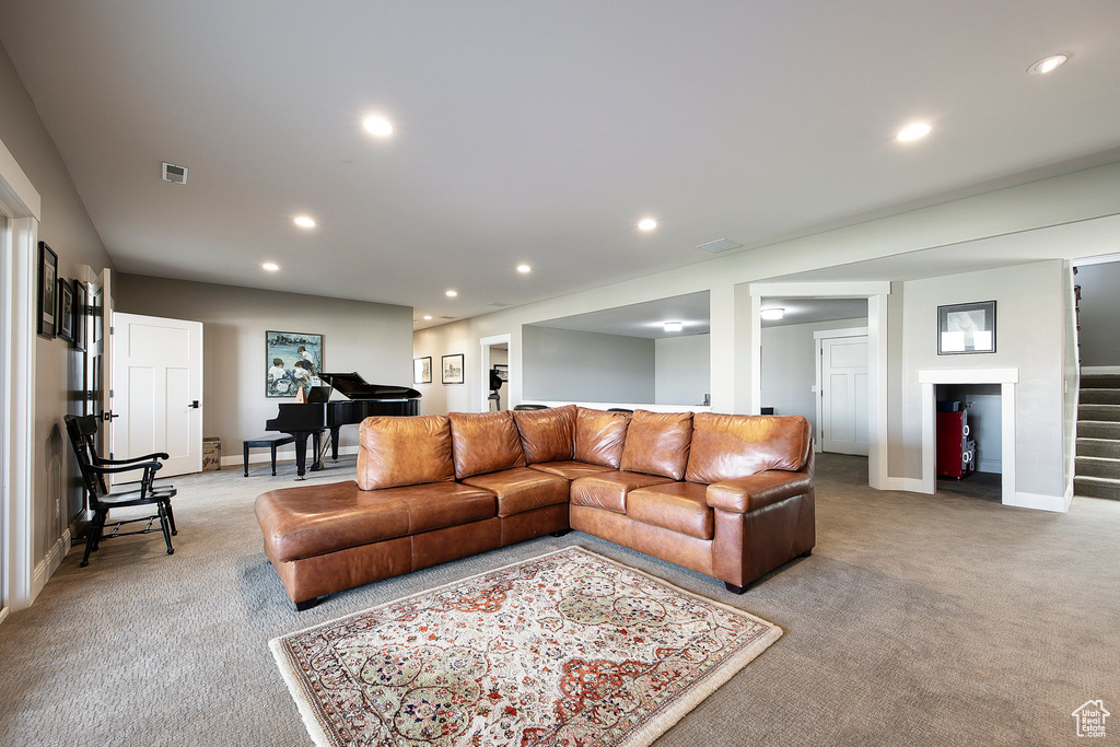 Carpeted living room featuring stairs, recessed lighting, and baseboards
