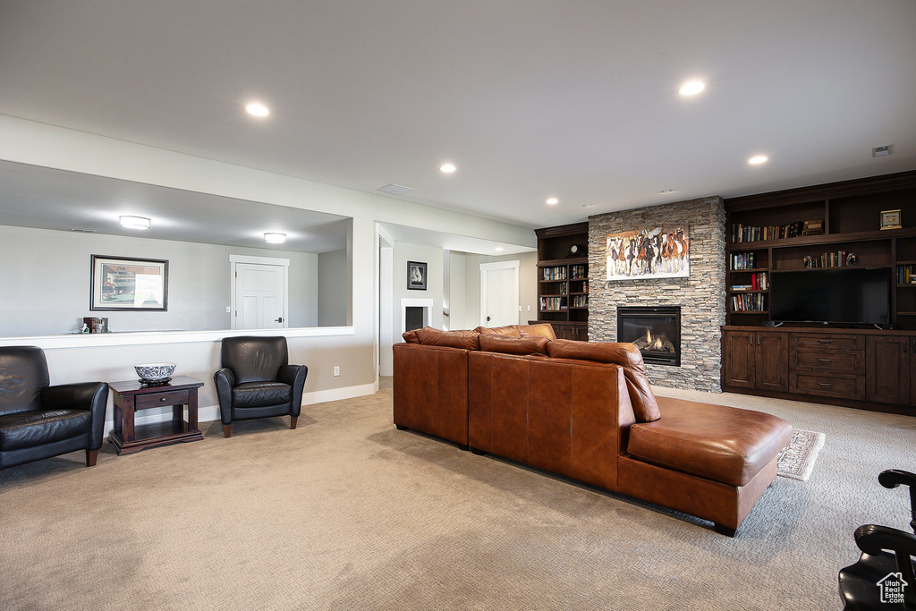 Living room featuring carpet flooring, a fireplace, baseboards, and recessed lighting