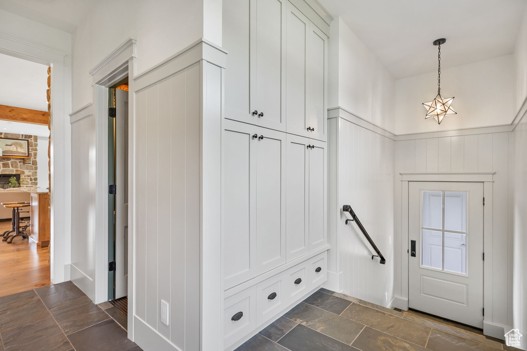 Mudroom featuring wainscoting and stone finish floor