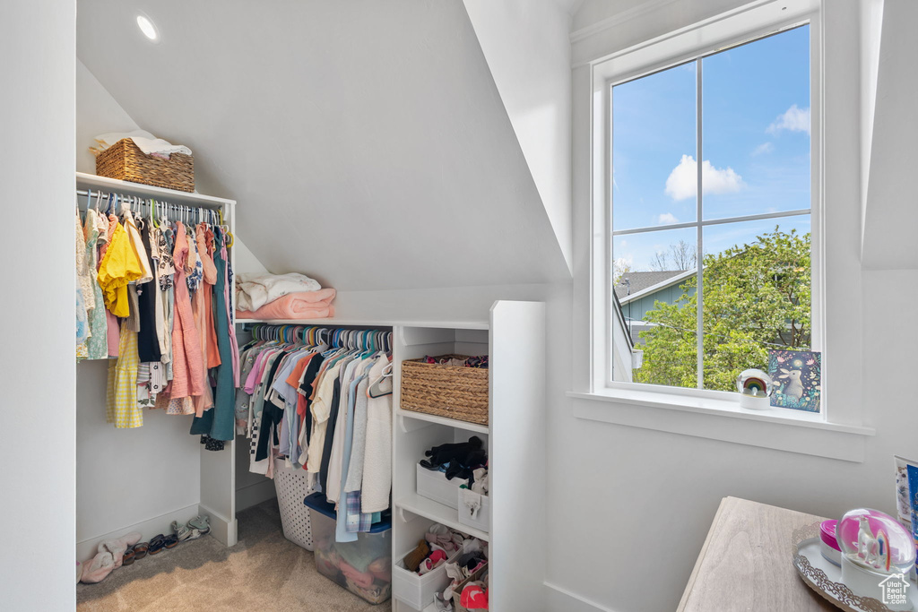 Walk in closet featuring vaulted ceiling and carpet flooring