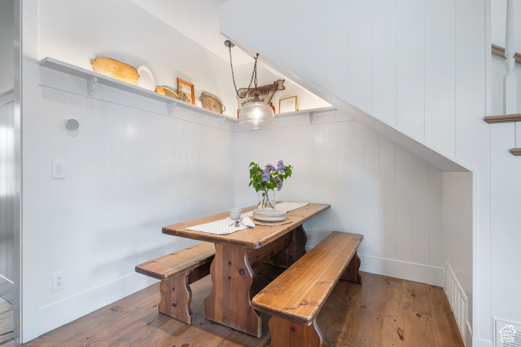 Dining space featuring a decorative wall, wood finished floors, and visible vents