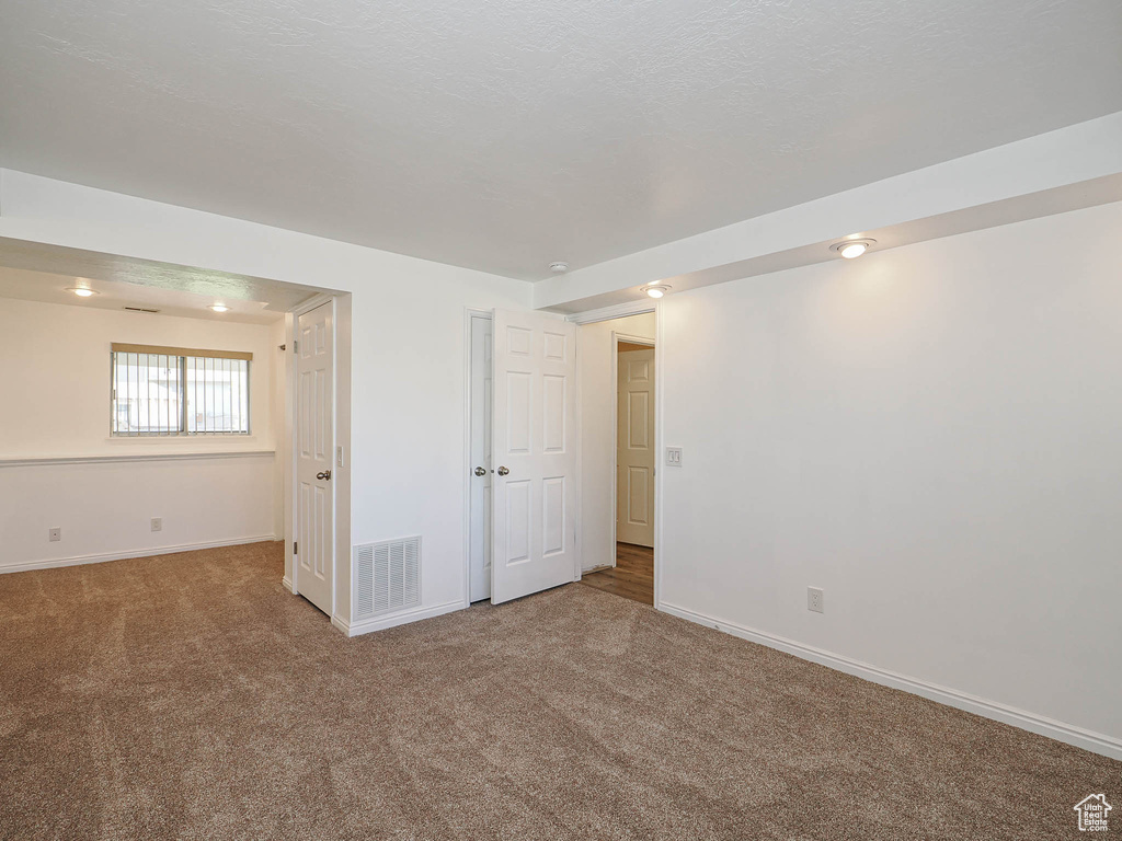 Interior space featuring baseboards, carpet flooring, and visible vents