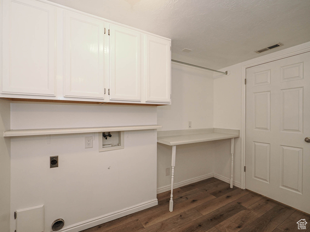 Washroom featuring hookup for an electric dryer, dark wood finished floors, visible vents, washer hookup, and cabinet space