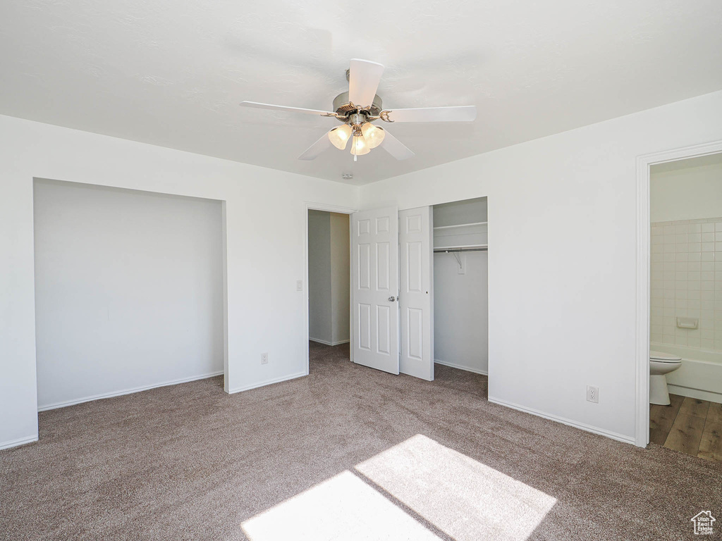 Unfurnished bedroom featuring carpet floors, baseboards, ceiling fan, and connected bathroom