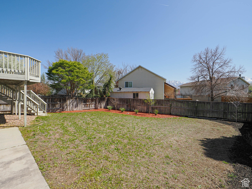 View of yard featuring a fenced backyard, stairs, and a deck