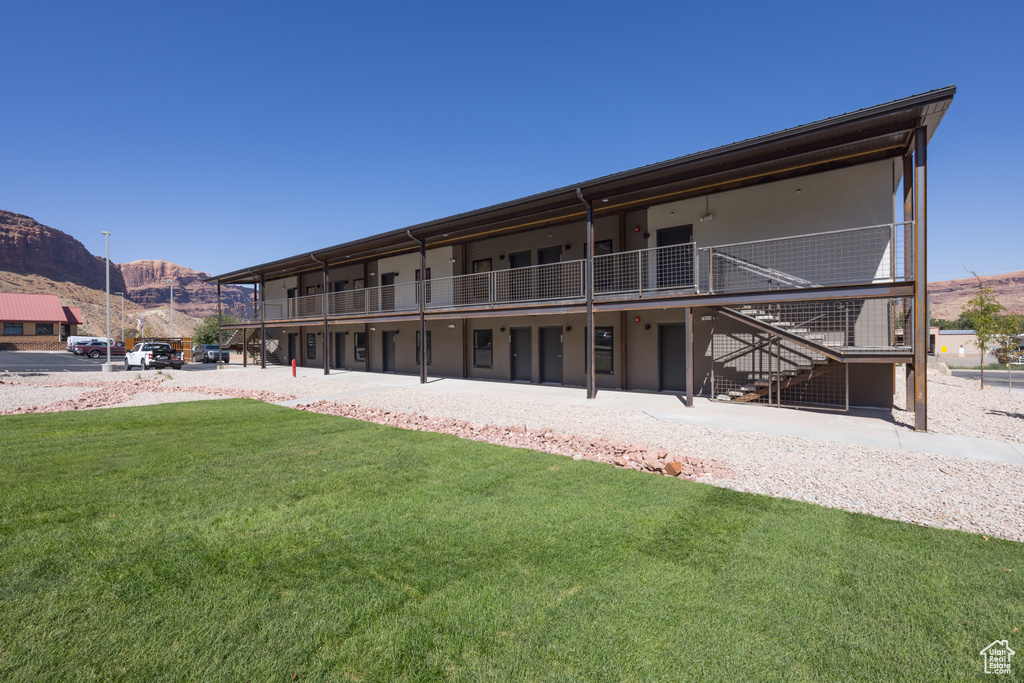 Exterior space with a mountain view, stairway, and a lawn