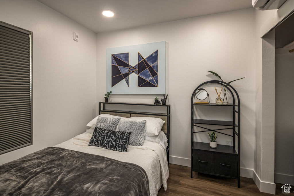Bedroom with wood finished floors and baseboards