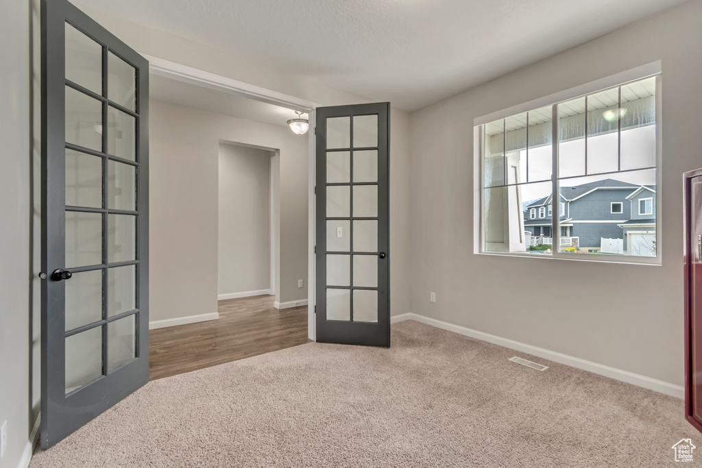 Unfurnished room with french doors, carpet floors, and baseboards